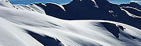 Schneebedeckte Berglandschaft mit klaren Konturen und Schatten