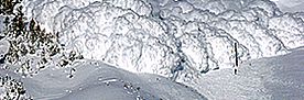 Lawine aus Schnee und Eis rollt einen Berghang hinab.