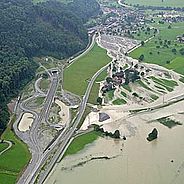 Sicht aus der Luft auf den über die Ufer getretenen Sarnersee und das entsprechend überflutete Kulturland.