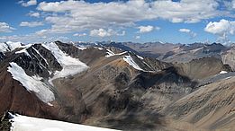 Berglandschaft in Kirgisistan mit mehreren unbenannten Gletschern unter blauem Himmel mit Wolken
